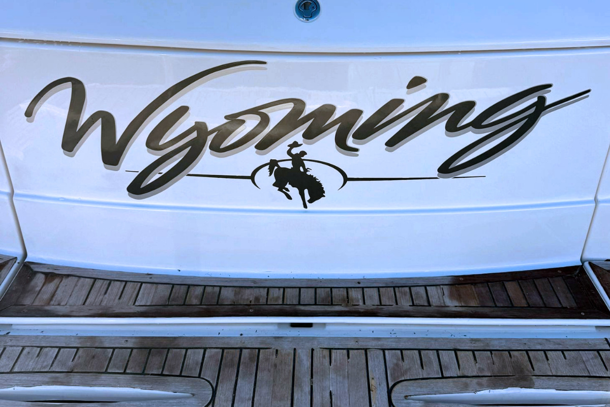 close up of back of Perth boat Wyoming displaying cursive boat name sign with graphic