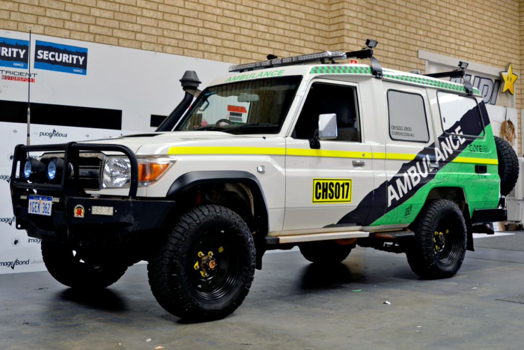 Mine spec Signage Perth Ambulance MINE SPEC DOESN’T HAVE TO BE BORING: WHEN COMPLIANCE MEETS BRANDING 11 4wd ambulance parked in warehouse displaying mine site compliant signage and branding graphics