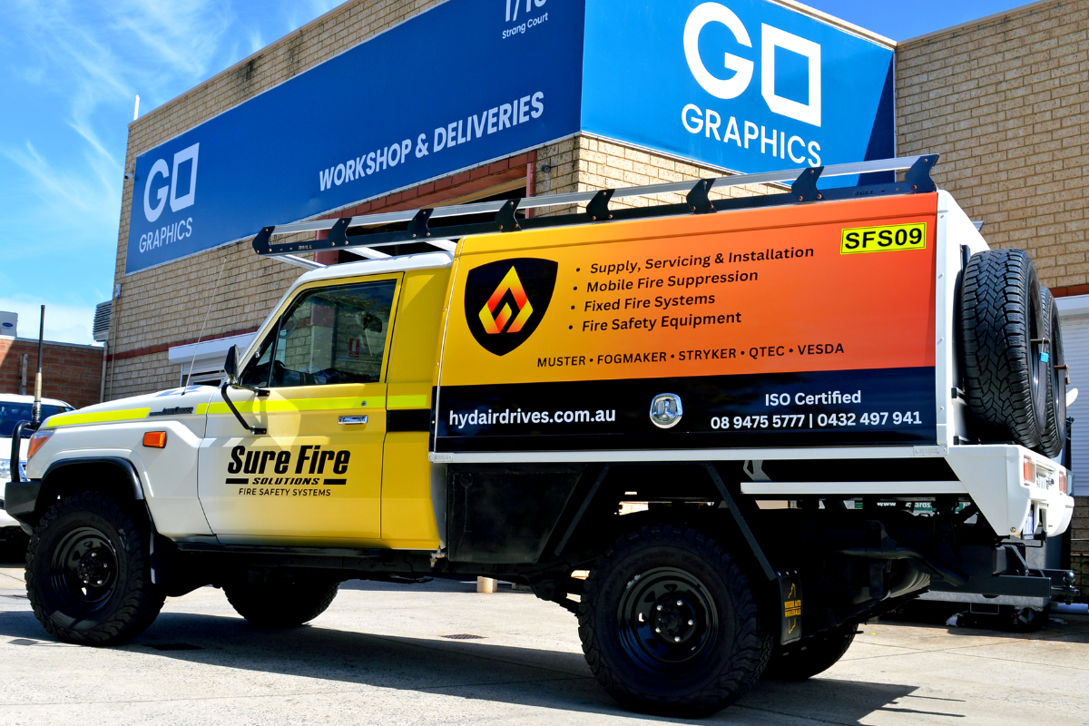 Mine spec Signage Perth Sure Fire Mine Spec Signage Perth 20 SureFire solutions ute displaying branded vehicle graphics and compliant mine spec signage parked outside Go Graphics warehouse