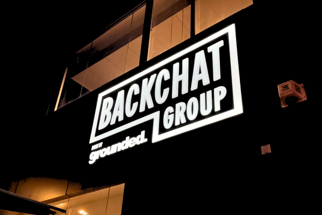 Exterior commercial Perth commercial building at night time showing illuminated logo sign of BackChat Group lit up at night